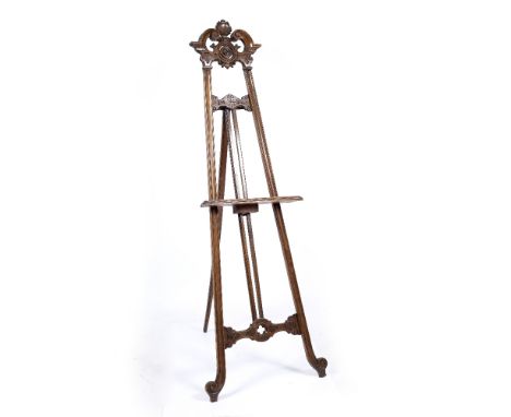 A VICTORIAN WALNUT GALLERY PICTURE EASEL with scrolling top and further carved decoration, 66cm wide x 178cm high