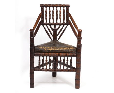 A 19TH CENTURY OAK TURNERS CHAIR with leather upholstered triangular seat and ring turned decoration overall, 60cm wide x 46c