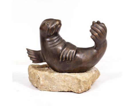A BRONZE FOUNTAIN IN THE FORM OF A SEAL mounted on a section of limestone, the seal 44cm wide x 27cm high, 40cm high includin
