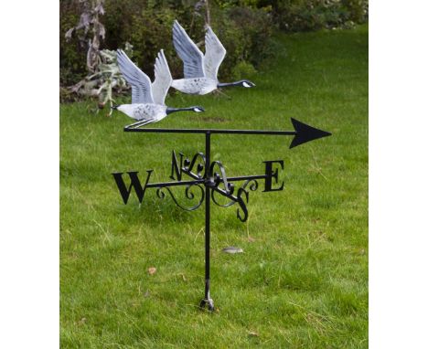 A WROUGHT IRON WEATHER VANE surmounted by two flying Canada geese, the weather vane displaying the cardinal points beneath, a