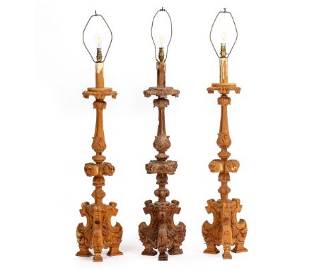 AN ANTIQUE CARVED PINE ALTAR CANDLESTICK with carved acanthus leaf and ornament and tripod base, 107cm high to the top of the