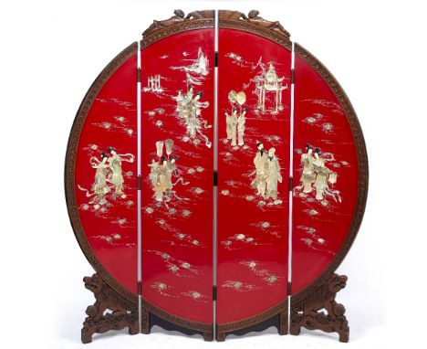 A JAPANESE STYLE RED LACQUERED MOON SCREEN four fold design with carved flower head and figural frame around the central fiel