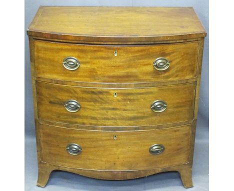 REGENCY CROSSBANDED MAHOGANY BOW FRONT CHEST of three drawers with oval backplates and swing handles on corner bracket feet, 