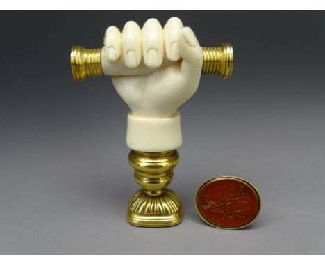 VICTORIAN DESK &amp; FOB SEALS, the desk seal of carved ivory in the form of a hand gripping a baton, having gilt metal ends 