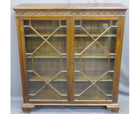 MAHOGANY TWO DOOR BOOKCASE with thirteen pane astragal glazed doors and interior adjustable shelves, having blind fret detail