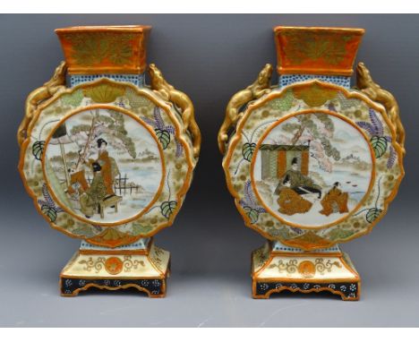 JAPANESE KUTANI MOON/PILGRIM FLASK VASES, a pair, circa 1920 with Chliong dragons to the shoulders, the central panels showin