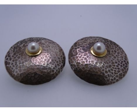 A PAIR OF 925 BEATEN SILVER 'DISC' EARRINGS, each with an offset single pearl set in a yellow metal colour, possibly gold rin