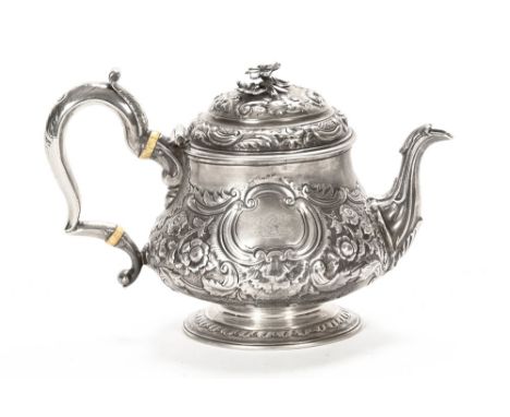 A bullet shaped silver teapot, with embossed lid and side crest within a cartouche, London 1778, maker Peter Podio.  16 cm hi