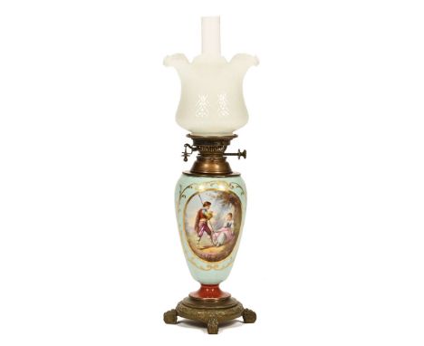 A late 19th century oil lamp, brass and ceramic with a Sevres style baluster shaped ceramic body with romantic painted scene,