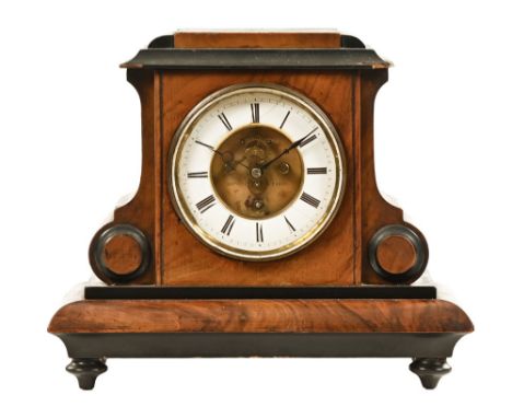 A late 19th century walnut cased mantel clock, of shaped architectural design containing a circular enamelled dial with Roman