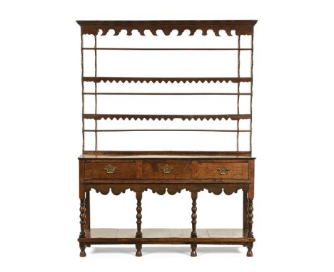 A 19th century oak dresser, with plate rack above a lower section with three frieze drawers above a shaped apron and four tur