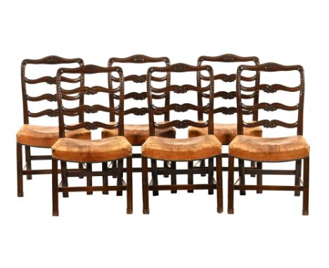 A set of six mahogany ladder back dining chairs, with carved top rails and back with leather upholstered seats and raised on 