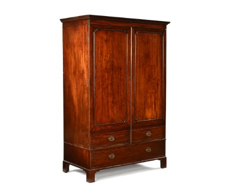 A George III mahogany wardrobe, with detachable moulded dentil cornice above a pair of doors with centre brass edging strip a