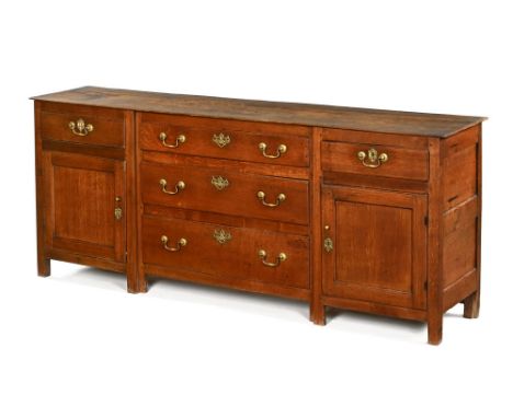 An 18th century oak dresser base, the rectangular top above three central graduating drawers flanked by two single drawers an