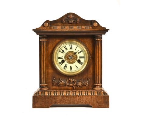 An oak mantel clock with enamelled dial, with paper label to interior H.A.C. 14 day strike made in Germany.  Height 34 cm, wi