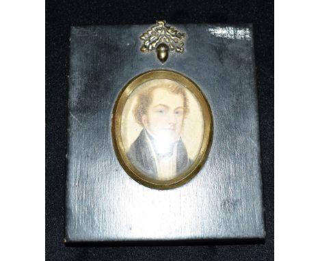 AN OVAL PORTRAIT MINATURE OF A REGENCY GENTLEMAN  in reproduction papier mache type frame with acorn finial Condition Report 