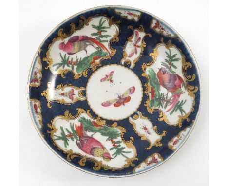 An 18th century Worcester shallow dish, decorated with reserves of fabulous birds and insects to a scale blue ground, seal ma