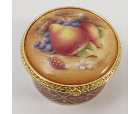 A Royal Worcester circular box, the cover hand painted with fruit by J Bowman, with gilt metal mount, boxed