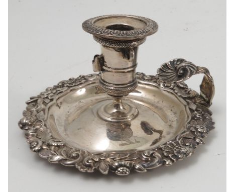 A Georgian silver taper stick, by Rebecca Emes and Edward Barnard, London 1820, the circular base with rococo border, the han