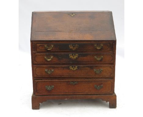 A 19th century oak bureau, the fall flap opening to reveal central cupboard flanked by secret drawers and pigeon holes, with 