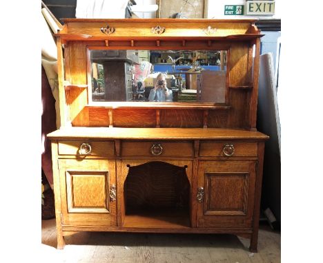 An Arts and Crafts oak sideboard, in the style of Shapland and Petter, the superstructure with a central mirror flanked by pa