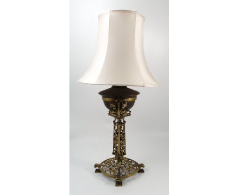 An Art Nouveau pierced gilt metal lamp base, converted from an oil lamp, the column and base decorated with scrolls and leave