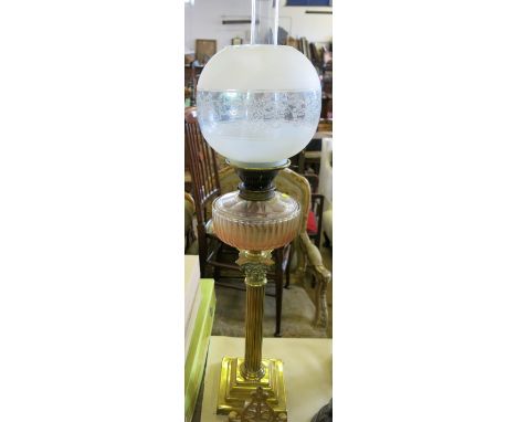 A brass oil lamp, of Corinthian column form, with glass reservoir and frosted glass bowl and chimney, height 31ins 