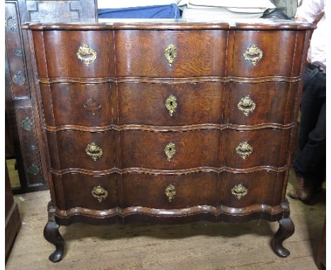 A 19th century Continental oak break front chest, of double serpentine outline, fitted four long drawers, raised on cabriole 