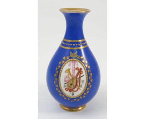 A Kerr & Binns Worcester vase, of baluster form, the blue ground decorated with gilt and an oval cartouche with musical instr