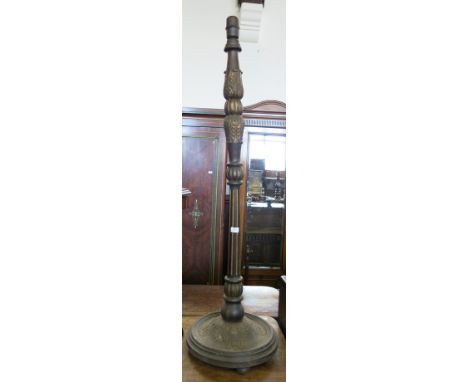 An ebonised and turned wooden standard lamp, raised on a circular base