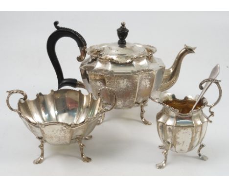 A silver three piece tea set, the fluted body with c scroll edge, raised on scroll legs with shaped foot, Birmingham 1900 and