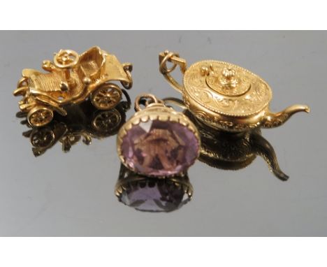 A 9ct gold tea pot charm, together with a 9ct gold vintage car charm, and an amethyst 9ct gold seal charm, weight 16.7g gross