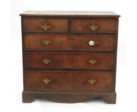 A Georgian oak chest of drawers, fitted two short drawers over three graduated long drawers above a shaped frieze, width 43.5