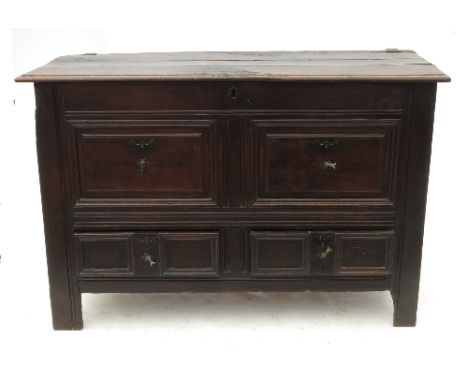 An 18th century oak mule chest, having plain rising lid above fielded panels, fitted two drawers below, width 52ins 