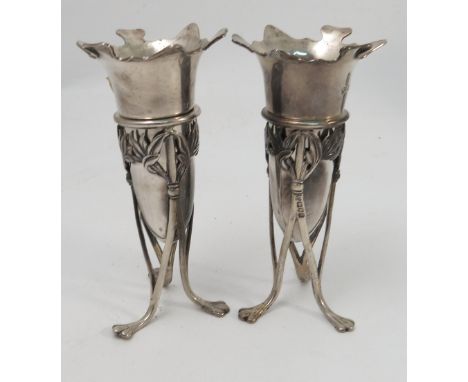 A pair of silver epergne stands, with pierced leaf decoration raised on triform base and outswept feet, each supporting a tru