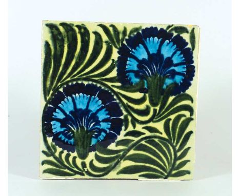 A William De Morgan pottery tile painted with two blue flower heads and green leafage on a pale green ground, impressed mark,