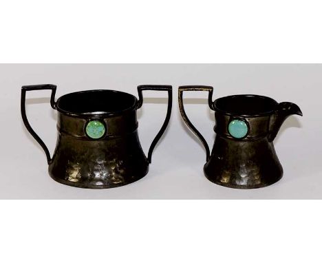 An Ashberry Pewter hammer textured two handled sucrier and matching cream jug, each with angular handles and applied circular