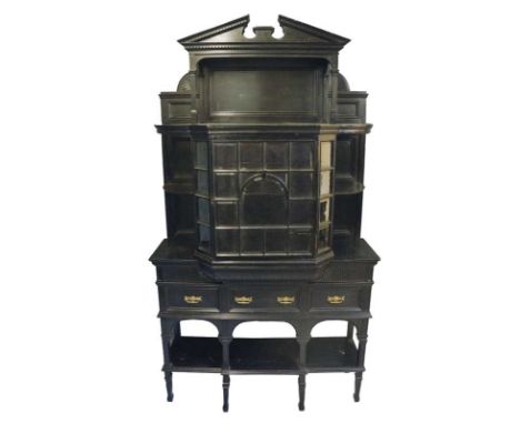 Gregory & Co. - an ebonised display cabinet with broken architectural pediment above a dentil frieze and open back, the centr