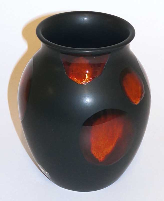 A Poole pottery "living glaze" vase the matt black body with red orange spots, 16.5 cm high, prin