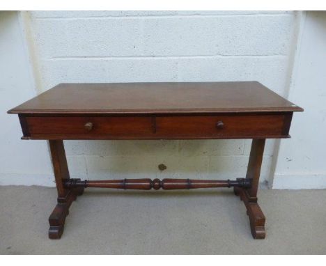 A Victorian mahogany two drawer side table with shaped ends and a turned tapering stretcher. 