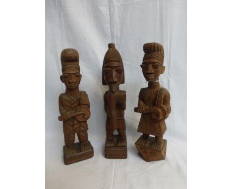 LAMIDI O. FAKEYE (Nigerian 1928 - 2009) - three yoruba mahogany carvings of three figures playing musical instruments raised 