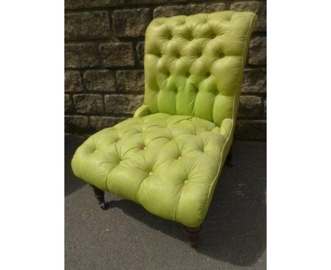 A Victorian button back upholstered nursing chair raised upon faux mahogany supports. 
