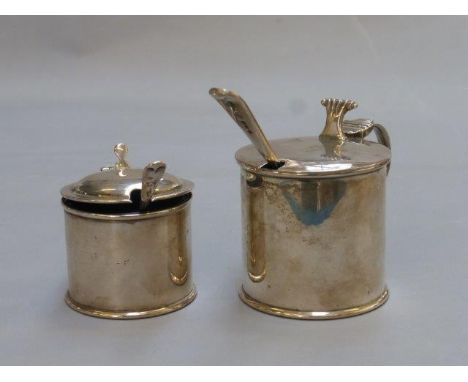 Two silver mustard pots with blue glass liners and spoons, maker's  mark indistinct, Chester 1915 and W. Hutton & Sons Ltd, C