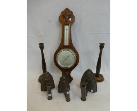 An oak cased barometer, a pair of oak candlesticks and three flat irons. 