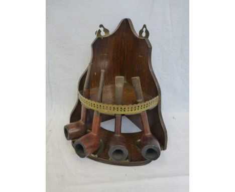 An oak corner pipe rack with four pipes: a BBB, a Corsica, a Pulteneya and a Yorkist.