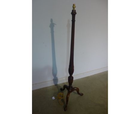 An Edwardian mahogany standard lamp with shaped and reeded column enhanced with carved wheaters, all supported on triple cabr