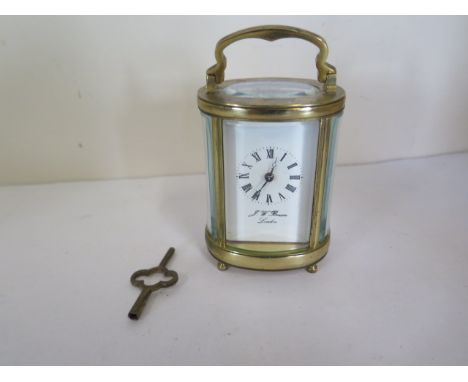 A J W Benson brass carriage clock, oval in shape, white enamel face, 8.5cm H, 6.2cm Wide, running, no apparent damage, some w