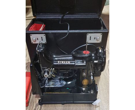 A Singer 222K Featherweight sewing machine, cased with accessories including button holer, various feet/attachments, quilting