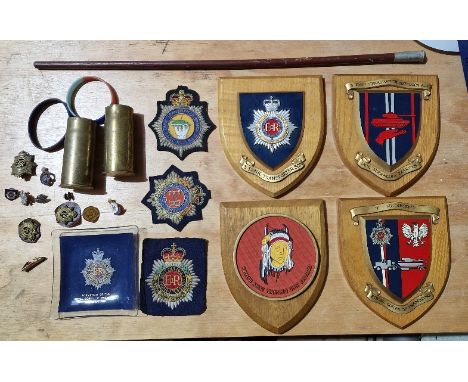 A collection of assorted militaria to include 4 x wooden shields, various cap badges, various cloth badges, swagger stick, 2 