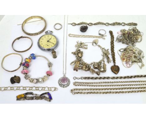 A hallmarked silver charm bracelet set with various charms to include a mantel clock, a policeman's helmet, a trophy cup, a c